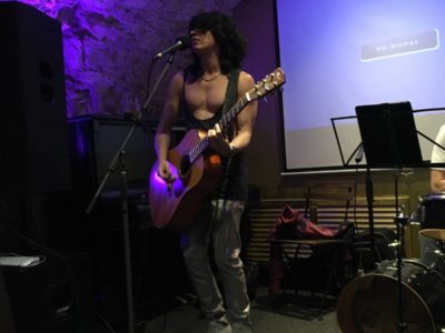 Kytarista v tílku hraje v jazz baru na Malé straně během narozeninové party